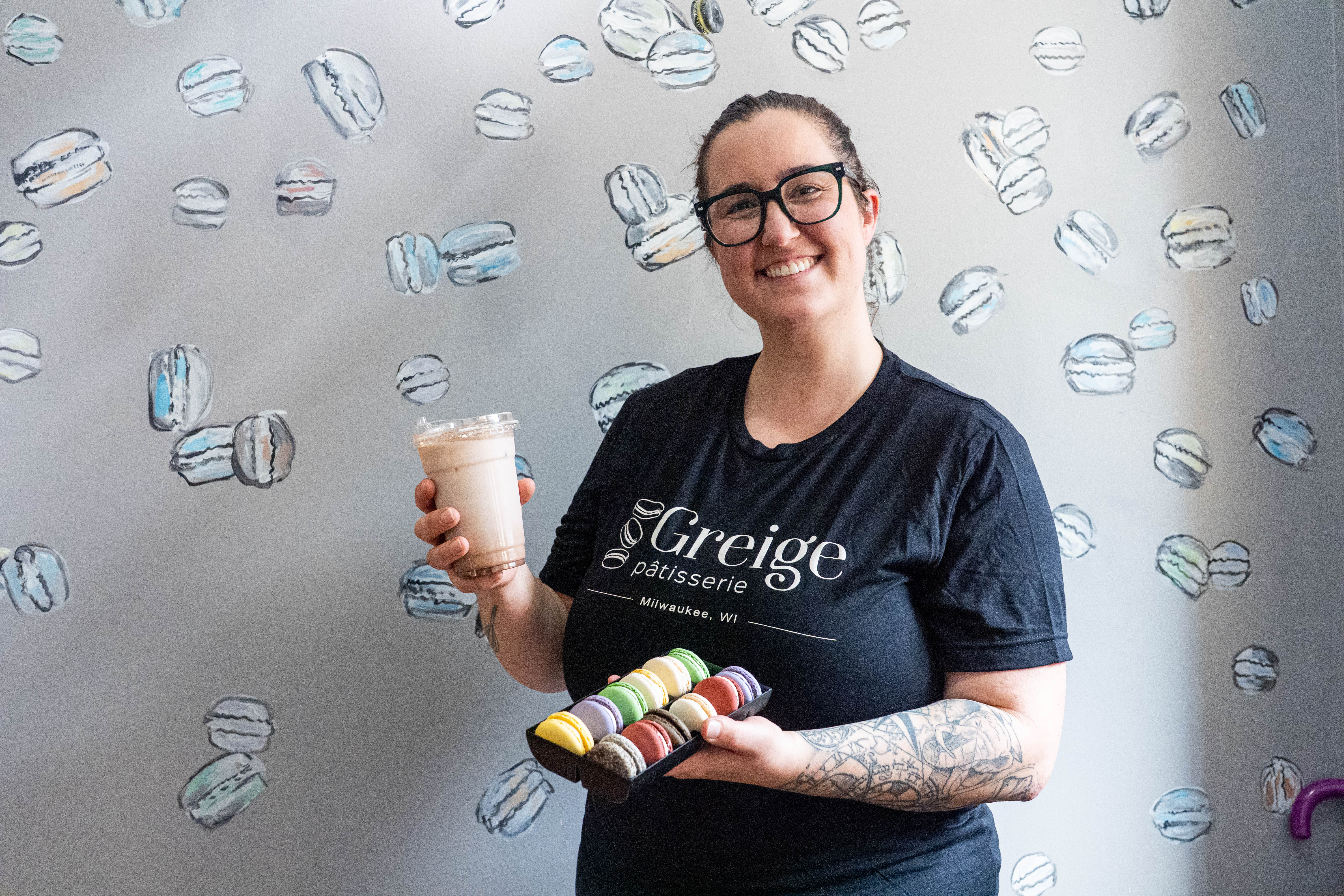 Jessica Reinhardtsen in a black shirt holds a coffee in a to-go cup