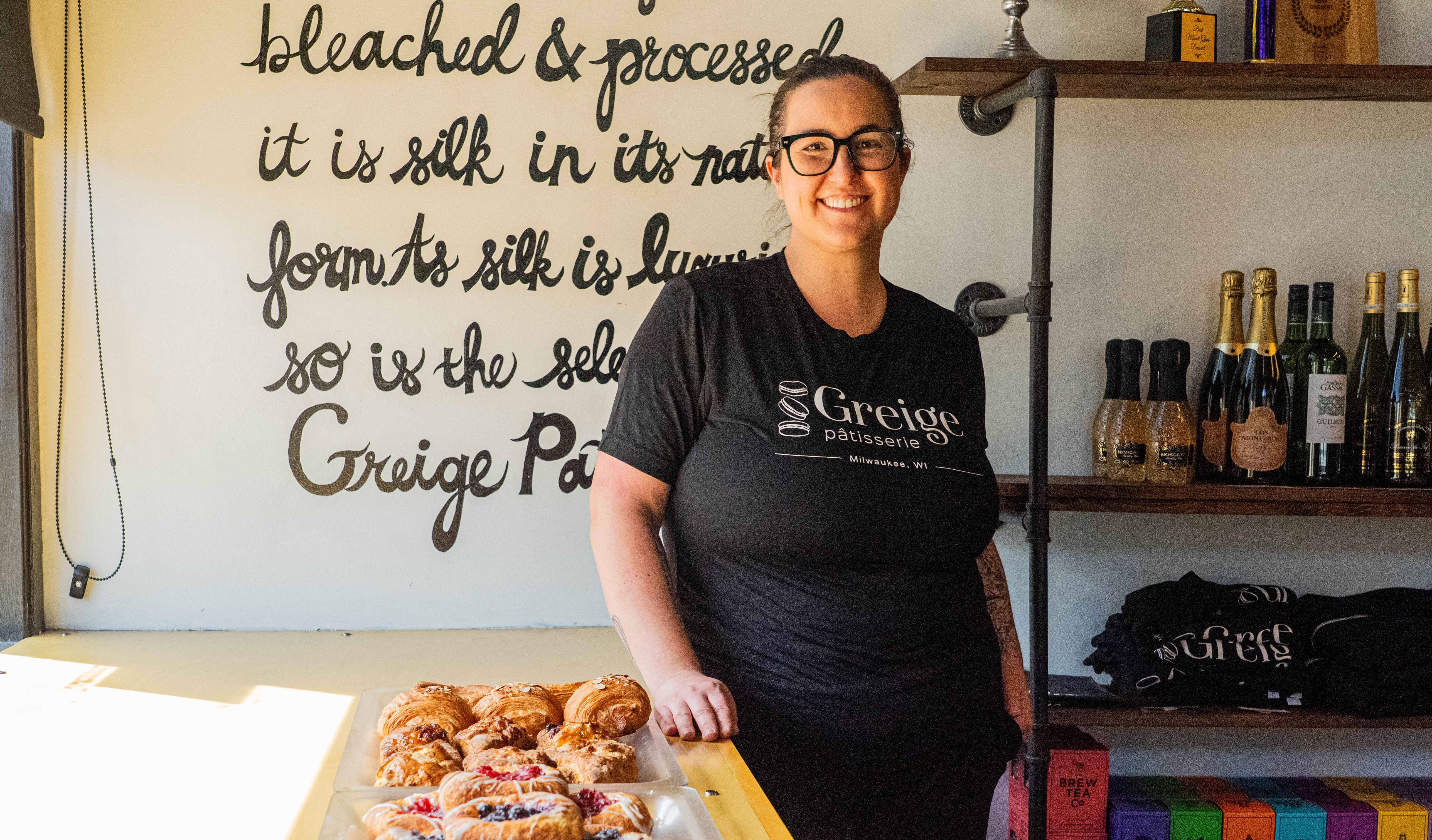 Jessica Reinhardtsen stands at a counter in her bakery with a tray of pastries next to her