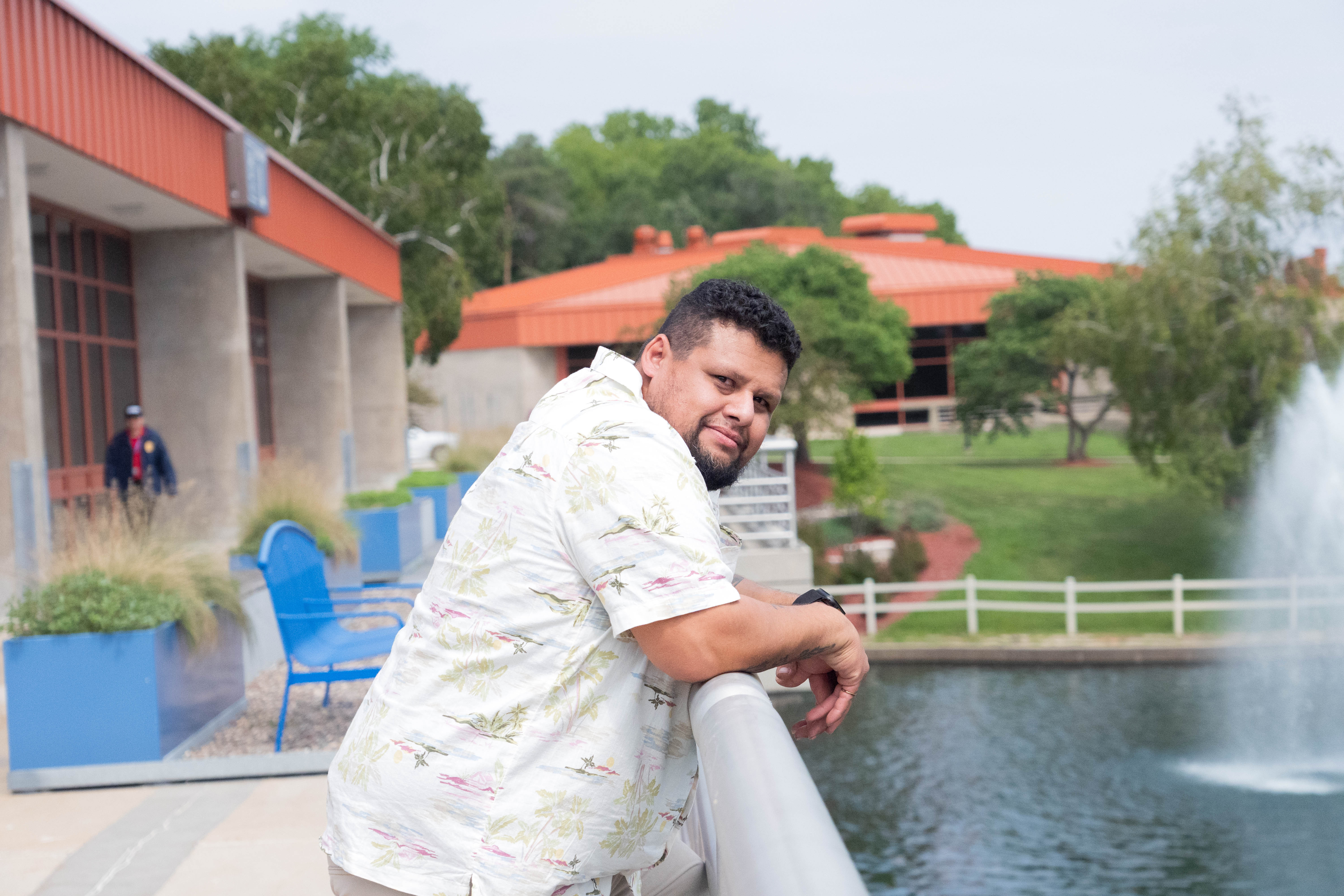 John Molina leans on his elbows over a railing and looking over his shoulder at the camera
