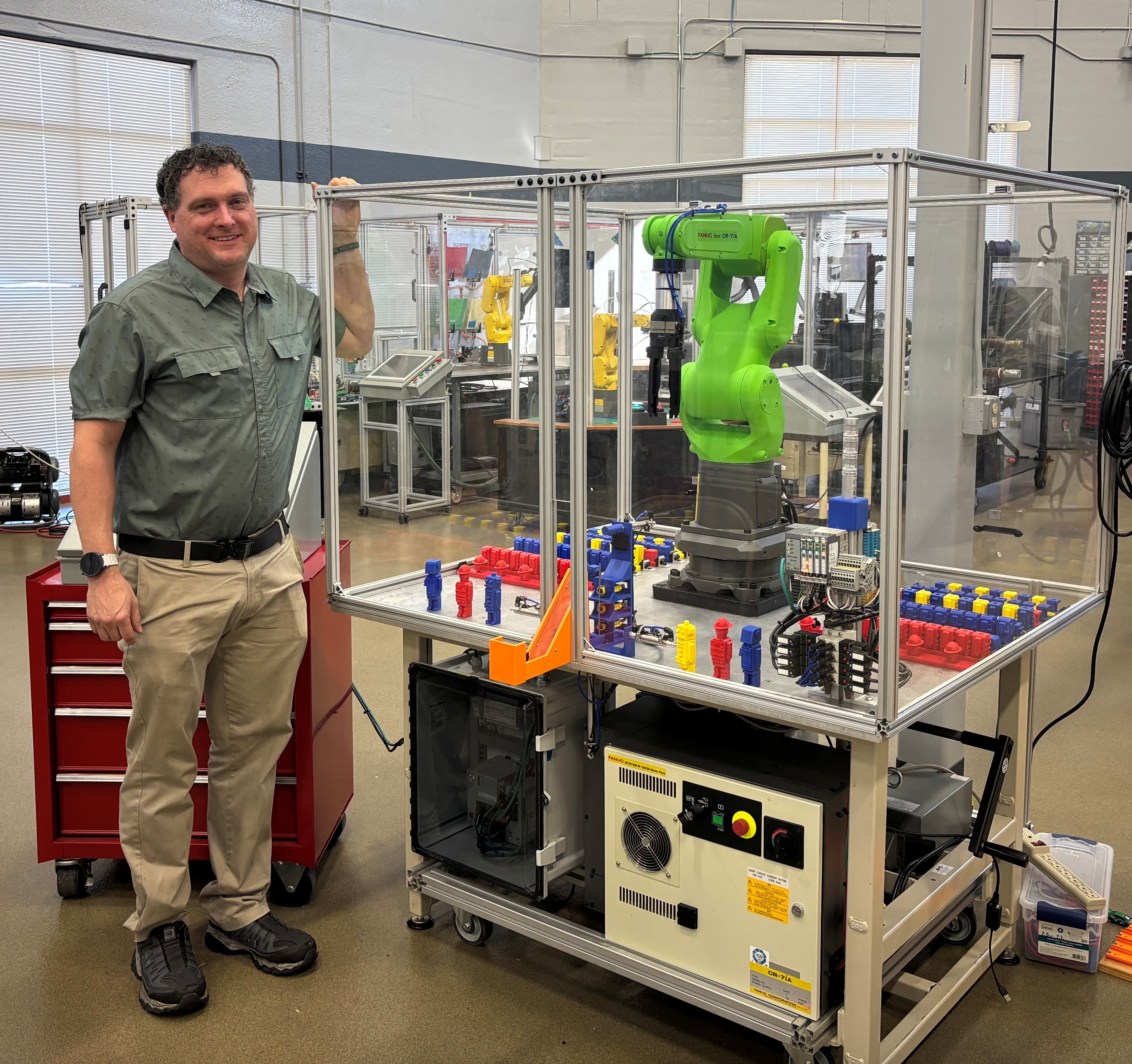 WCTC male grad next to automation machine