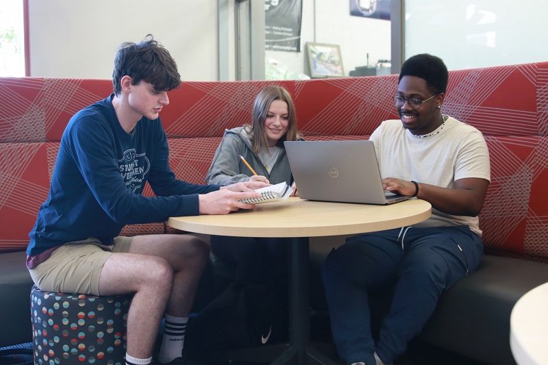 Three students working together at table