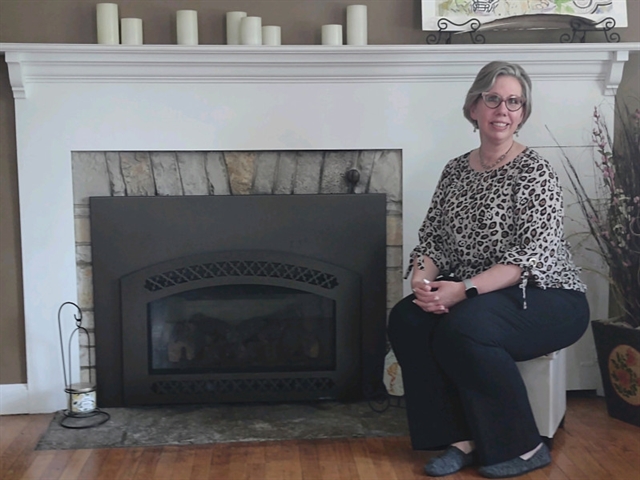 Trena Anderson sitting by fireplace
